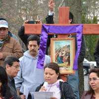 <p>A woman speaks at one of the crosses used in the Mount Kisco re-enactment.</p>