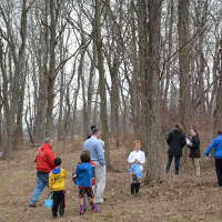 <p>Kids and adults walk through the woods at Chappaqua Crossing for the fire department&#x27;s Easter egg hunt.</p>