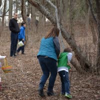 <p>Attendees walk in the woods of Chappaqua Crossing during the local Easter egg hunt.</p>