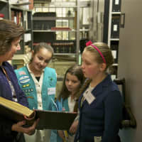 <p>Town Clerk Betsy Browne shows the Girl Scouts the records room.</p>