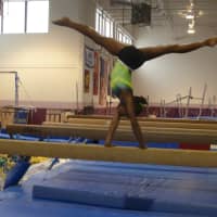 <p>Carlee Reid does a handstand on the balance beam.</p>