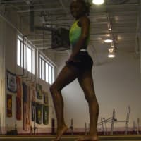 <p>Carlee Reid of Stamford poses on the balance beam.</p>