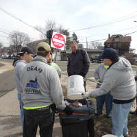 <p>The group empties garbage theyve picked up into large trash cans.</p>
