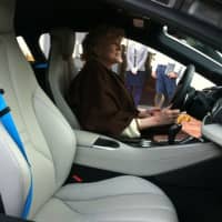 <p>Leslie Lee sits inside a BMW 18 plug-in hybrid sports car. Stamford-based nonprofit Sustainable America held an event Tuesday showcasing electric and hybrid cars.</p>