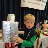 <p>Owen Reardon with his robot made out of used tin foil and boxes.</p>