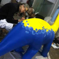 <p>Barbara Post Campbell paints her dinosaur during an open house at the artists studio. </p>