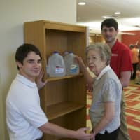 <p>Sacred Heart students work with Irma Peopon, testing her ability to lift the full jugs.</p>