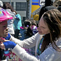 <p>A volunteer fits a child with a new bike helmet.</p>
