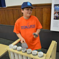 <p>Nate Meyer, at fifth-grader at Seven Bridges Middle School, demonstrates his project, which is called &quot;Tubular&quot; and is similar to the musical instrument arrangement for Blue Man Group.</p>