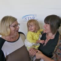 <p>Grace Bennett (left) with Wolf Grace, 2, and mom Kate Bagnati, meet with author Liz Murray (right).</p>