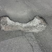 <p>A pothole on Park Avenue in the village of Harrison.</p>
