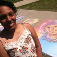 <p>Sasha Cubero, 20, from Bridgeport, a Fine Arts student stands beside her portraiture at the Sidewalk Art Festival.</p>