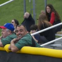 <p>Spectators watch from the outfield fence.</p>