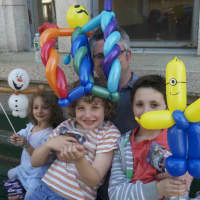 <p>(L to R): Miel (3), Neveh (7), and Liam (9) enjoy balloon creations as dad Noah Yechiely peeks out from behind balloons. </p>