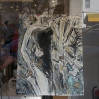 <p>Art is displayed in the window of Stuart Weitzman.</p>