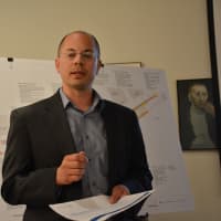 <p>Anthony Ciriello of Milone &amp; MacBroom, the consulting firm working on the Scotts Corners overhaul. A map of the proposal is in the background.</p>