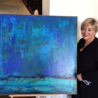 <p>Jane Ubell-Meyer poses with one of her paintings.</p>