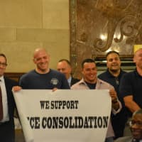 <p>Mount Kisco policemen display a banner in favor of the police consolidation with Westchester County.</p>