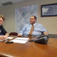 <p>Mamaroneck Village Manager Richard Slingerland, left, and Assistant Village Manager Dan Sarnoff sit at Town Hall, where a FEMA flood map of Mamaroneck stays on the wall. </p>