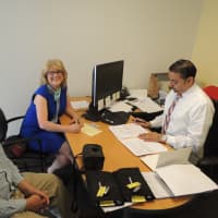 <p>Bill Casale, director of operations of STAR and Katie Banzhaf, executive director of STAR, sign paperwork for new vans.</p>