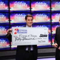 <p>CNN Anchor John Berman accepts a ceremonial check from Alex Trebek, host of Celebrity Jeopardy! </p>
