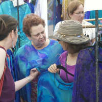 <p>Visitors check out clothing booths.</p>