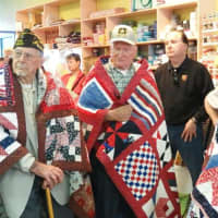 <p>Veterans are wrapped in quilts made in the Quilts of Valor program at Christie&#x27;s Quilt Shop in Norwalk.</p>