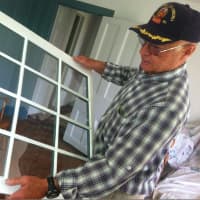 <p>Steve Gravereaux holds up half of a restored window in the Hanford-Silliman House.</p>