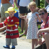 <p>A young boy and a girl wave flags as they watch the parade Monday in Weston.</p>