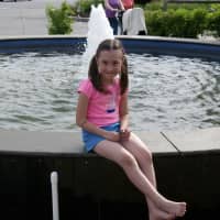 <p>A young girl enjoys the fountain at Chamber of Commerce Park.</p>