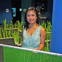 <p>Kiara Baguio, a junior at Brien McMahon High School, displays a maze she created that demonstrates threats to migrating sea turtles.</p>