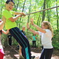 <p>Columbus Elementary fourth grader Wilson Jiang navigates the low ropes course at the Taconic Outdoor Education Center with help from his classmates.</p>