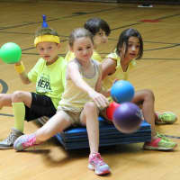 <p>From left, second-graders Owen Wiate, Olivia Stramandinoli, Mack Haymond and Rhea Rai took part in Crossfire, an event where teams tried to knock down bowling pins from wheeled carts.</p>
