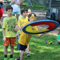 <p>Connor Kelley, a third-grade yellow team member, throws a giant Frisbee while teammates Vaughn Silcox, Connor Blenke and June Qin watch. </p>