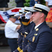 <p>A trio of Ossining firefighters give salutes in the Katonah parade.</p>