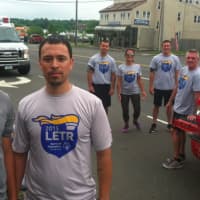 <p>Sebastian Rojas, left, and his cousin, Norwalk Police Officer Phil Taborda along with other Norwalk Police Officers in the background participated in the Norwalk section of the Law Enforcement Torch Run.</p>