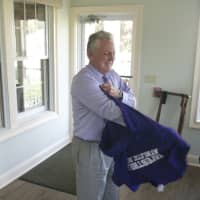<p>Mayor Harry Rilling changes into his new Westhill basketball T-shirt at Wednesday&#x27;s lunch.</p>