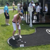 <p>A fan tries her hand at putting.</p>