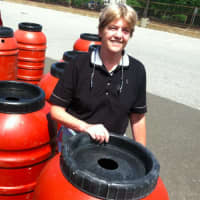 <p>Cindy Muskus from Stamford standing beside a water barrel. She purchased her second one this year through SkyJuice, a New Hampshire company, and Aquarion.</p>