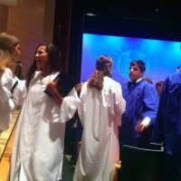 <p>Two graduates excitedly talk after the graduation ceremonies at Darien High School Tuesday.</p>