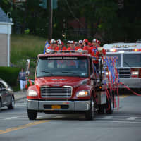 <p>Byram Hills baseball team players can be seen in the background for the celebration parade in Armonk.</p>