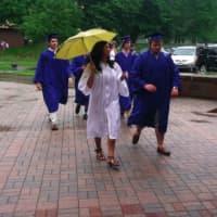 <p>Graduates walk in the rain as they head for Wilton High School to gather for the graduation ceremony.</p>
