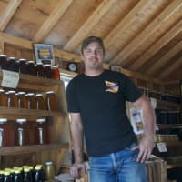 <p>Mike Bruen inside his truck in Brewster, where he offers honey and other bee products.</p>