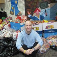 <p>Dr. Benjamin A. Dancygier, of Valley Pediatric Dentistry, sits in front of last years giant pile of donated Halloween candy.</p>