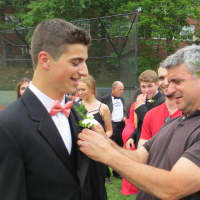 <p>A dad pinned a boutonniere on his son as his brother looked on.</p>