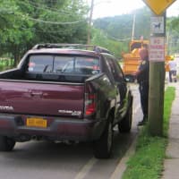 <p>A Rye police officer talking to the driver of this pickup, which suffered damage to the front right hood when winds blew a large limb onto Boston Post Road on Tuesday evening. No one was hurt.</p>