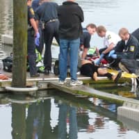 <p>Norwalk emergency personnel perform CPR on another of the victims pulled from a submerged car at Veterans Memorial Park Saturday. </p>
