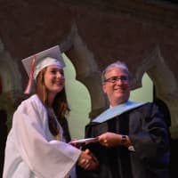 <p>A new Fox Lane High School graduate receives her diploma.</p>