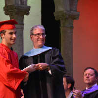 <p>A new Fox Lane High School graduate receives his diploma.</p>