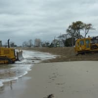 <p>Bulldozers create a wall of sand along Compo Beach in Westport Sunday in anticipation of the high ways expected with Hurricane Sandy. </p>